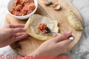 Femme pr&eacute;parant un rouleau de chou farci