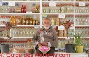  iranian man with rose petals in a shop selling rose water