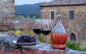 Deux verres de vin rouge et une bouteille de vin typique de chianti Fiasco