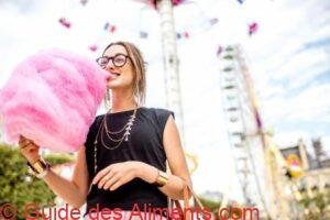 Femme avec barbe à papa au parc d'attractions
