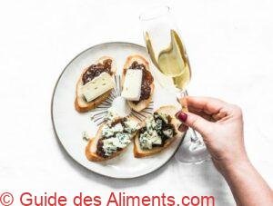 prosecco and a plate with fig jam, gorgonzola and brie cheese bruschetta