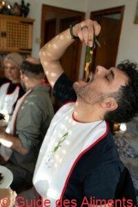 jeune homme mangeant du calçot avec sa sauce romesco